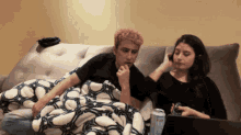 a man and a woman sit on a couch with a can of bud light