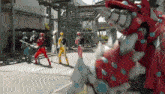 a group of power rangers are standing in front of a large red monster .