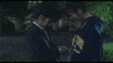 a woman in a suit kisses another woman in a blue sweatshirt