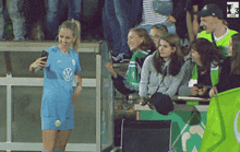 a woman in a vw shirt takes a selfie with her phone