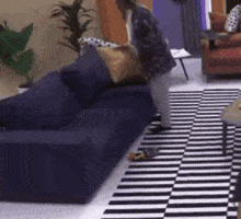 a woman is standing in front of a blue couch in a living room .