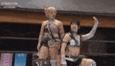two female wrestlers in a ring with a banner that says stardom