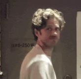 a man in a white shirt is standing in front of a door that has the number 248-250 on it