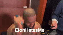 a man with a shaved head and the words elon hates me on his face