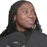 a woman with braids is standing in front of a microphone and smiling
