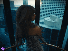 a woman in a snake print dress stands in front of a window