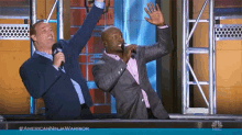 two men are standing in front of a sign that says #americanninjawarrior