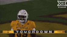 two football players are hugging each other in front of a banner that says touchdown