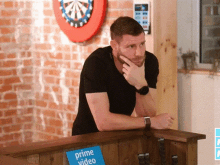 a man leans against a counter with a sign that says prime video on it