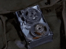 a close up of a tape recorder with two reels of tape on a table .