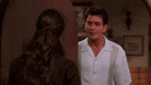 a man in a white shirt stands next to a woman