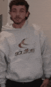 a man wearing a white hoodie that says sixteens on it