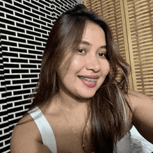 a woman with braces on her teeth is smiling in front of a black and white wall