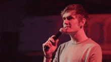 a man singing into a microphone with bam written in white