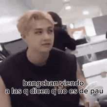 a young man is sitting in front of a mirror with a caption that says bangchan viendo a las q