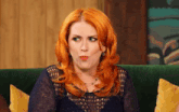 a woman with red hair is sitting on a couch