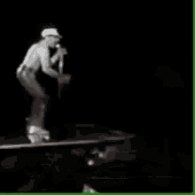 a man singing into a microphone on a stage in the dark