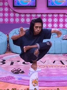 a man squatting on a cone in front of a tv screen that says ' brownies '