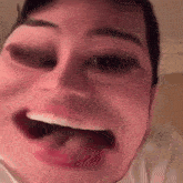 a close up of a person 's face with their mouth open and their tongue sticking out .