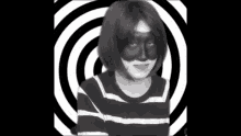 a woman wearing a black and white striped shirt and a black mask