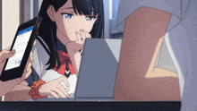 a girl is looking at a tablet while a person holds a cell phone