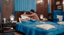a man and a woman are laying on a bed in a bedroom .