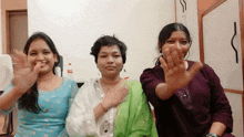 three women waving their hands in front of a coca-cola bottle