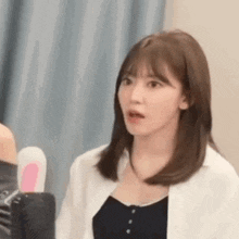 a close up of a woman making a funny face while standing in front of a microphone .