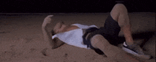 a man is laying on his back on a beach