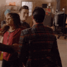 a man in a plaid shirt is talking to a woman