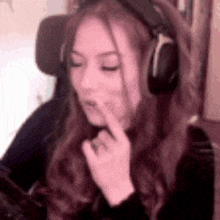 a woman wearing headphones is making a funny face while sitting in a chair .