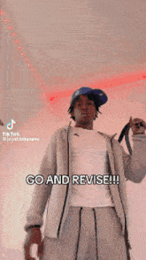 a man wearing a hat and a white shirt is holding a belt and says go and revise .