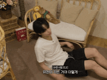 a man in a white shirt is laying on the floor next to a chair