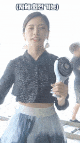 a woman in a crop top and skirt is holding a fan with chinese writing above her