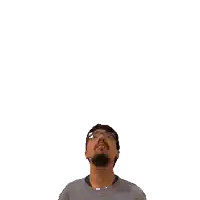 a man with glasses is looking up at a green cross on his head