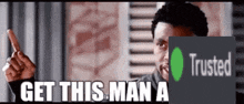 a man is pointing at a sign that says get this man a