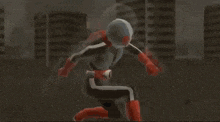 a man in a superhero costume kneeling down in front of buildings