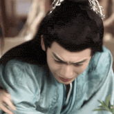 a man in a traditional costume is crying while a woman hugs him .