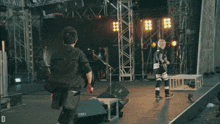 a crowd of people at a concert with the letter d in the corner