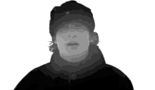 a black and white photo of a man with a hat on