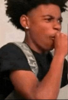 a young man is covering his mouth with his hand .