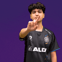 a man wearing a black shirt with aldi on the front