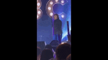 a man is singing into a microphone on a stage in front of a crowd