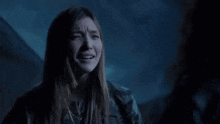 a woman is crying in a dark room in a dark room .