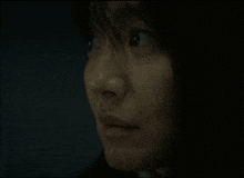 a close up of a woman 's face with a black background
