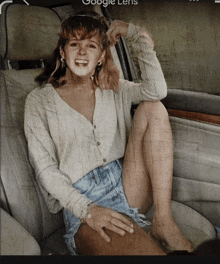 a woman is sitting in the back seat of a car with the words google lens visible in the corner
