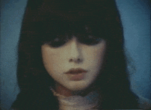 a close up of a woman 's face with long black hair