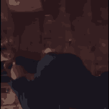 a person in a blue shirt is standing in a dark room looking into a refrigerator .