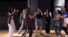 a group of young women are dancing in a room .