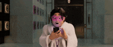 a man wearing a mask is looking at a cell phone